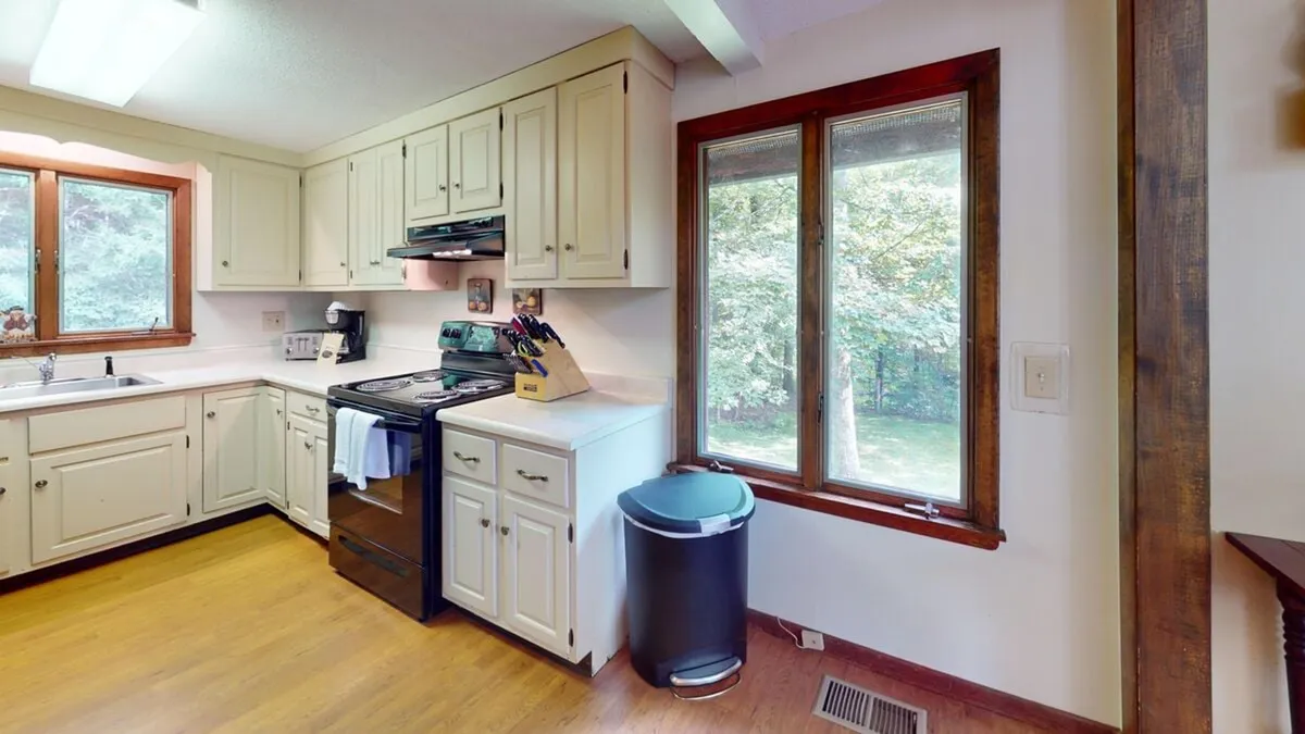 A bright, fully equipped kitchen is the focal point here, with stylish cabinetry, a stove ready for meal prep, and a window offering views of the outdoors. The kitchen is staged for family gatherings, baking, and hosting dinner parties, contributing to a warm and welcoming mood.