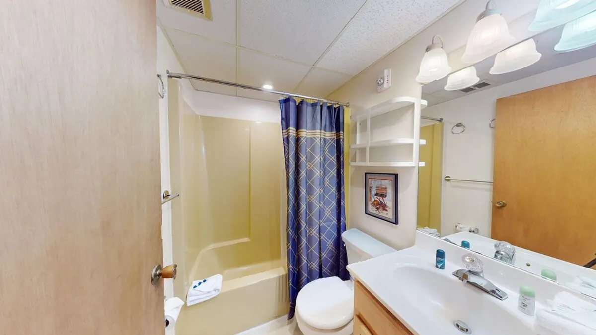 A thoughtfully designed bathroom with a bathtub, toilet, sink, and shower curtain. The mood is inviting and practical, illustrating a space perfect for self-care or refreshing after outdoor activities.
