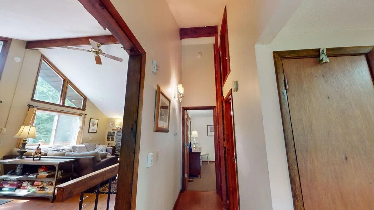 A warm, open living room area with comfortable seating and doorways leading to other rooms. The layout suggests easy movement between spaces and a communal area to relax and plan outings, with natural light creating an inviting atmosphere.